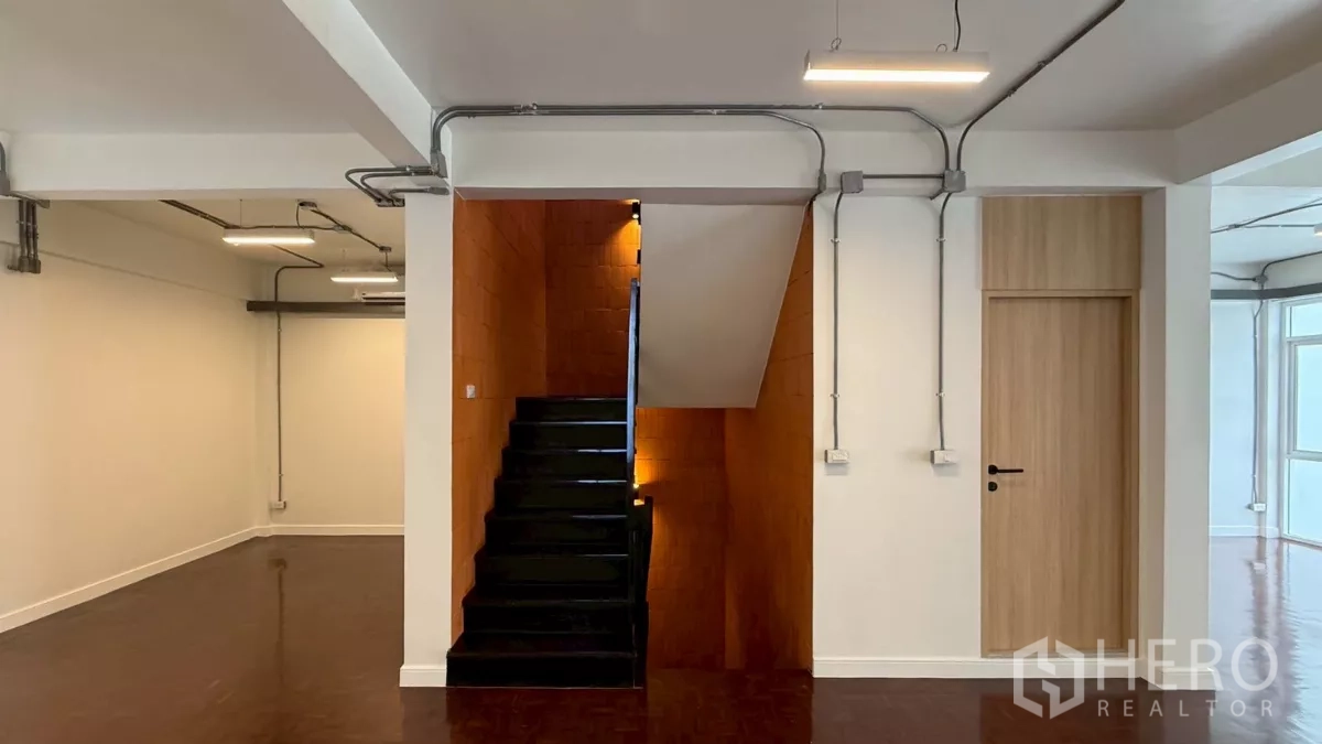 Home Office for rent in Watthana, Bangkok - Staircase with orange brick feature wall and clean white interiors.