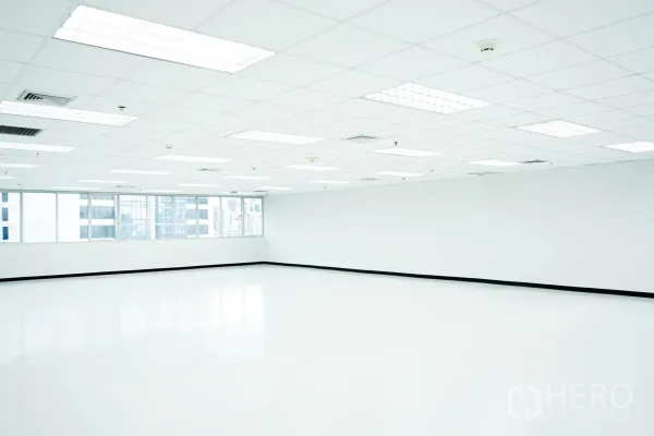 สำนักงาน ให้เช่าในWatthana, Bangkok - สำนักงานโอเพ่นสเปซสว่าง พื้นขาว ฝ้าเพดานตารางพร้อมไฟ และหน้าต่างมุมมองเมือง.