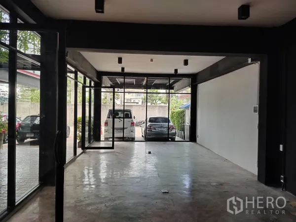 พื้นที่ขายปลีก ให้เช่า - ภายในแบบเปิดโปร่ง มองเห็นที่จอดรถผ่านผนังกระจกเต็มบาน พื้นคอนกรีต