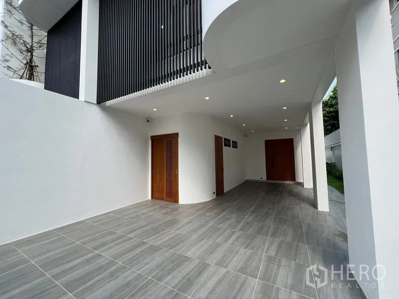 สำนักงานที่บ้าน ขายในPhra Khanong, Bangkok - ที่จอดรถในร่มใต้ตัวบ้าน พื้นกระเบื้องและประตูไม้.