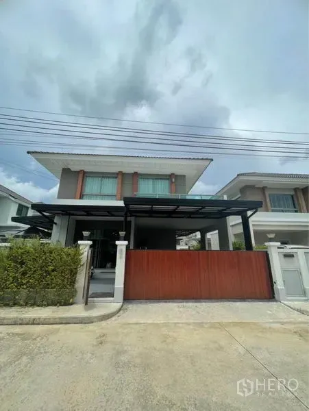 บ้าน ขายในLat Krabang, Bangkok - หน้าบ้านสไตล์โมเดิร์นสองชั้นพร้อมรั้วบานเลื่อนและโรงจอดรถมีหลังคา