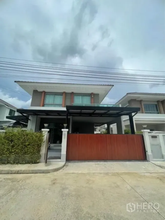 บ้าน ขายในLat Krabang, Bangkok - หน้าบ้านสไตล์โมเดิร์นสองชั้นพร้อมรั้วบานเลื่อนและโรงจอดรถมีหลังคา