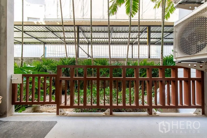 Condominium for rent in Phra Khanong, Bangkok - Condo terrace with wooden railing overlooking a tropical garden in Khlong Toei, Bangkok.