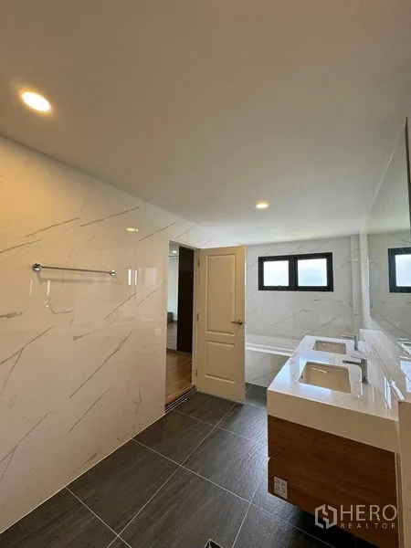 Detached House for rent in Don Mueang, Bangkok - Master bathroom with double vanity, large mirror and bathtub.