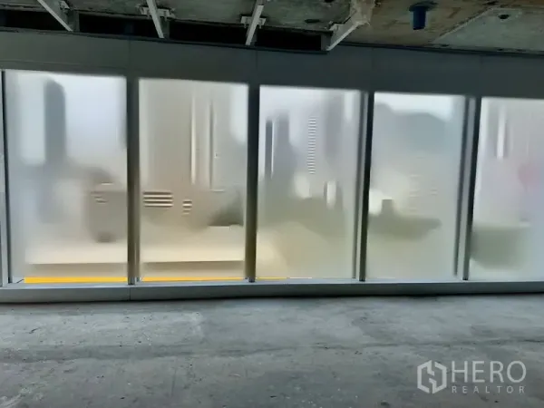 Office Space for rent in Sathon, Bangkok - Row of frosted floor-to-ceiling windows diffusing city light inside an unfinished office space.