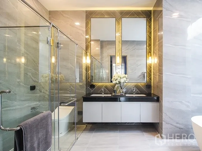 Detached House for rent or sale in Prawet, Bangkok - Modern bathroom with double vanity, glass shower and tiled walls.