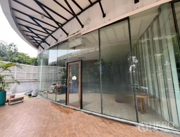 零售空间 出租 - 整面落地玻璃与带顶室外露台的零售店外观。