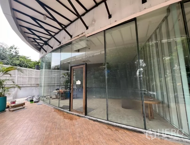 零售空间 出租 - 整面落地玻璃与带顶室外露台的零售店外观。