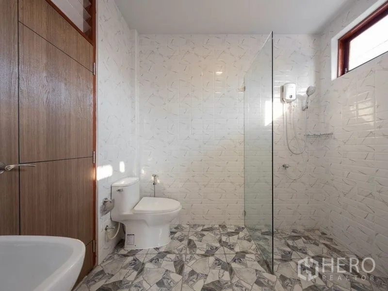 独立式住宅 出售在Chatuchak, Bangkok - 卫浴间设玻璃干湿分离，白色纹理墙砖与花纹地砖。