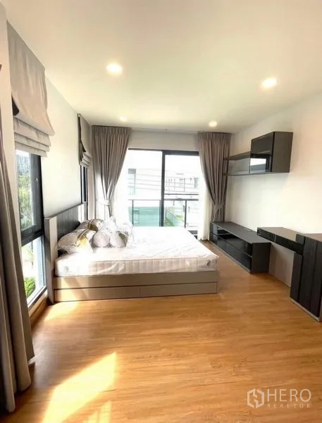 Detached House for rent - Sunlit bedroom with wood flooring, large windows with curtains, built-in desk and a queen bed.