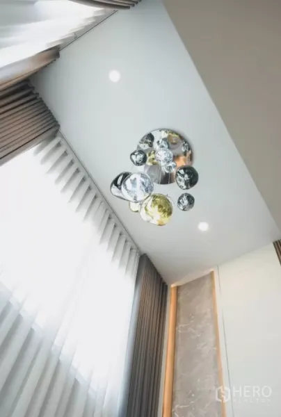 Detached House for rent in Bang Phli, Samut Prakan - Statement multi-globe chandelier hanging from high ceiling beside tall curtains.