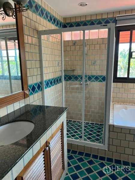 Detached House for rent in Bang Phli, Samut Prakan - Bathroom with granite-top vanity, glass shower enclosure and colorful patterned tiles.
