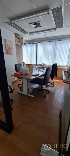 Office Space for rent in Watthana, Bangkok - Compact meeting room with table and chairs, ceiling air-conditioning vent, and large windows with blinds.