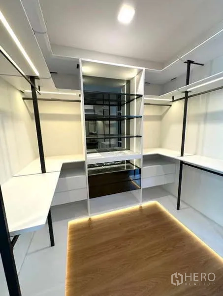 Detached House for rent in Samut Prakan - Spacious walk-in wardrobe with central glass shelving and LED lighting.