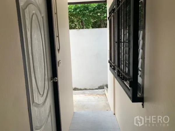 บ้าน ให้เช่าในKhlong Toei, Bangkok - โถงทางเดินข้างบ้าน หน้าต่างติดเหล็กดัดและประตูออกสู่ลาน