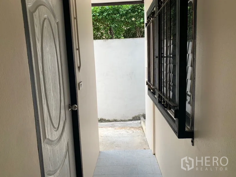 บ้าน ให้เช่าในKhlong Toei, Bangkok - โถงทางเดินข้างบ้าน หน้าต่างติดเหล็กดัดและประตูออกสู่ลาน