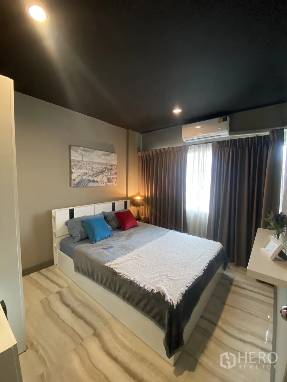 Townhouse for rent in Bang Kapi, Bangkok - Bright bedroom with white bed, air-conditioning and stone-look floor tiles.