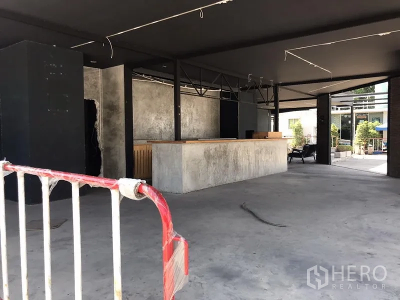 零售空间 出租在Khlong Toei, Bangkok - 开阔式室内空间，水泥地面，长形服务吧台，吊顶与梁架外露。