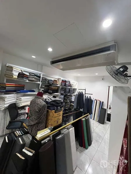 零售空间 出租在Khlong Toei, Bangkok - 储物间，布料卷与白色货架，墙挂式空调。