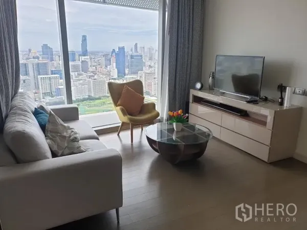 คอนโด ให้เช่าในPathum Wan, Bangkok - ห้องนั่งเล่นพร้อมชั้นวางทีวี โต๊ะกลางกระจก และหน้าต่างกระจกเต็มบานวิวสกายไลน์