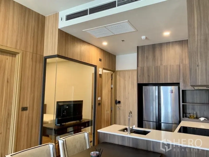 คอนโด ขายในWatthana, Bangkok - โซนครัวและรับประทานอาหารตกแต่งผนังไม้ กั้นด้วยกระจกกับมุมทำงาน