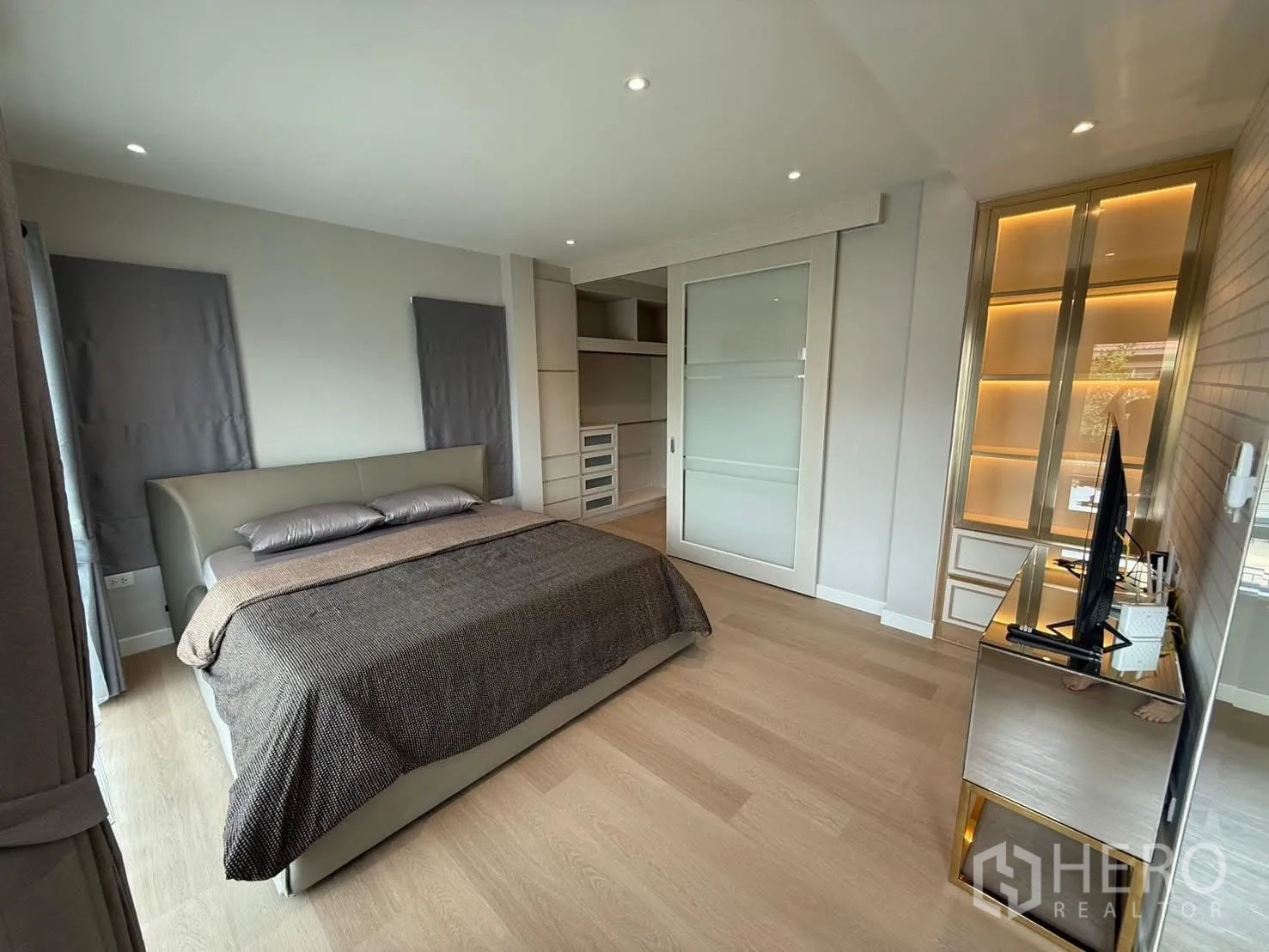 Detached House for rent in Prawet, Bangkok - Master bedroom with built-in wardrobe, illuminated display cabinet and TV console.