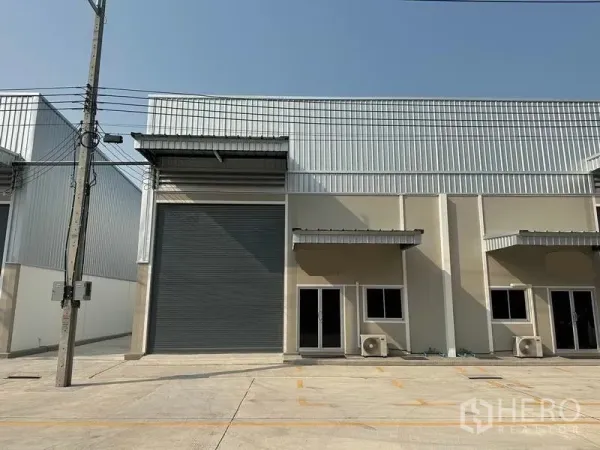Factory for rent in Bang Phli, Samut Prakan - Front facade of a single factory unit with high roller door and glass office entrance.