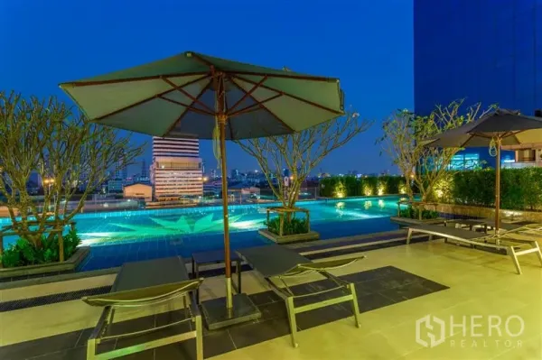 คอนโด ให้เช่าในChatuchak, Bangkok - สระว่ายน้ำดาดฟ้ายามค่ำ พร้อมเตียงอาบแดดและวิวเมือง