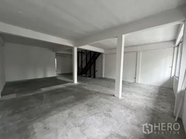店屋 出租在Watthana, Bangkok - 开放式楼层，水泥地面、白色墙面与结构立柱。