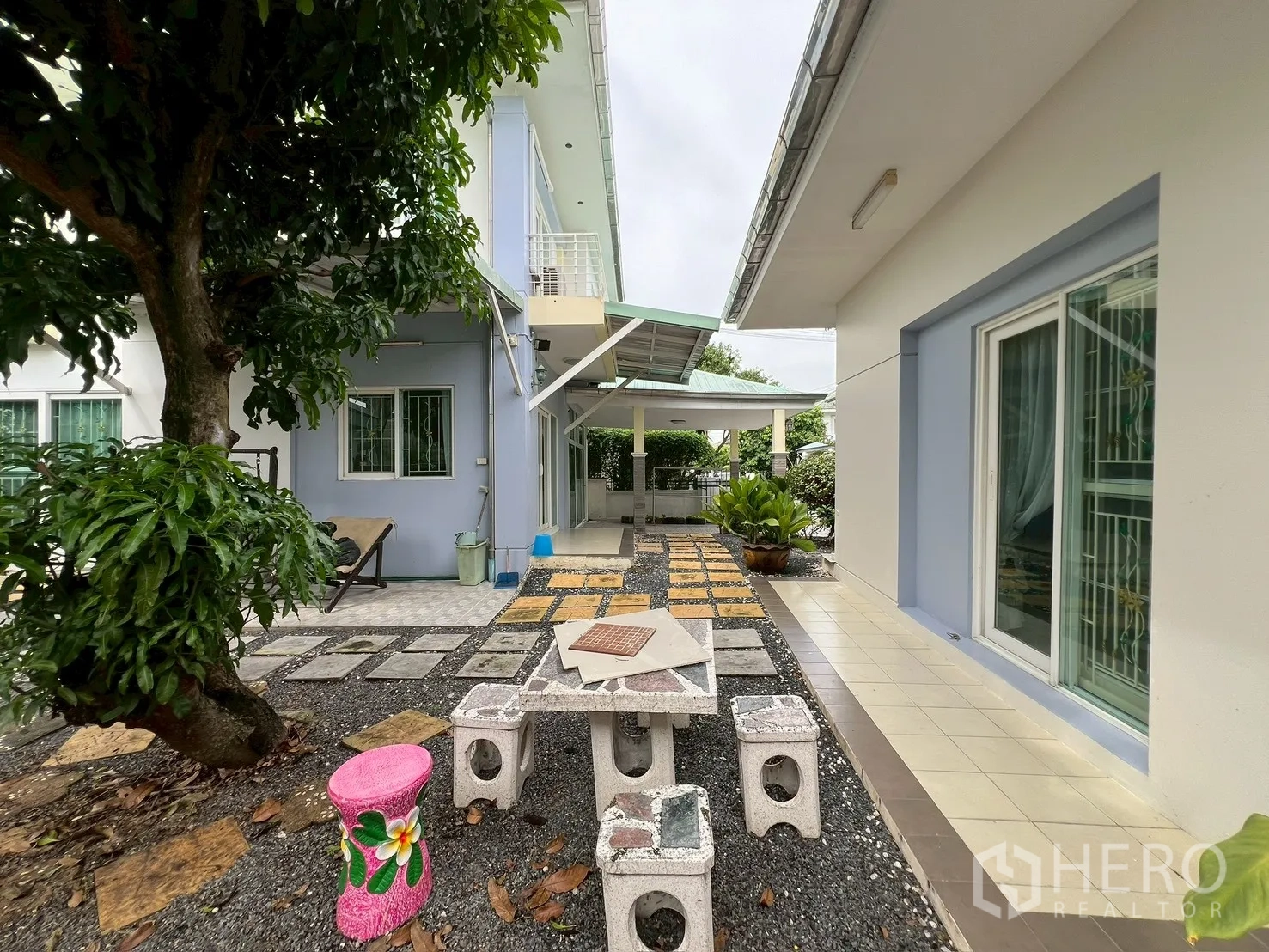 บ้าน ขายในMin Buri, Bangkok - ลานสวนระหว่างบ้านหลักกับเรือนรับรอง มีชุดโต๊ะหิน