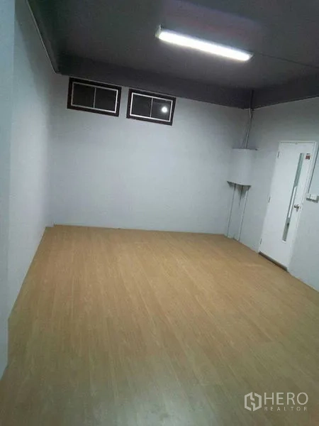 店屋 出租在Khlong Toei, Bangkok - 楼上空房，浅木色地板、白墙与小窗户。