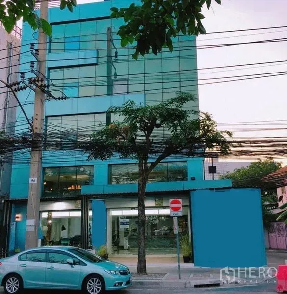 Shophouse for rent in Khlong San, Bangkok - Blue glass-fronted multi-storey shophouse exterior on a city street.