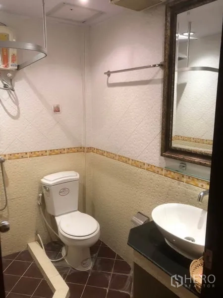 店屋 出租在Bang Rak, Bangkok - 浴室内有坐便器、台上盆、镜子与淋浴区。