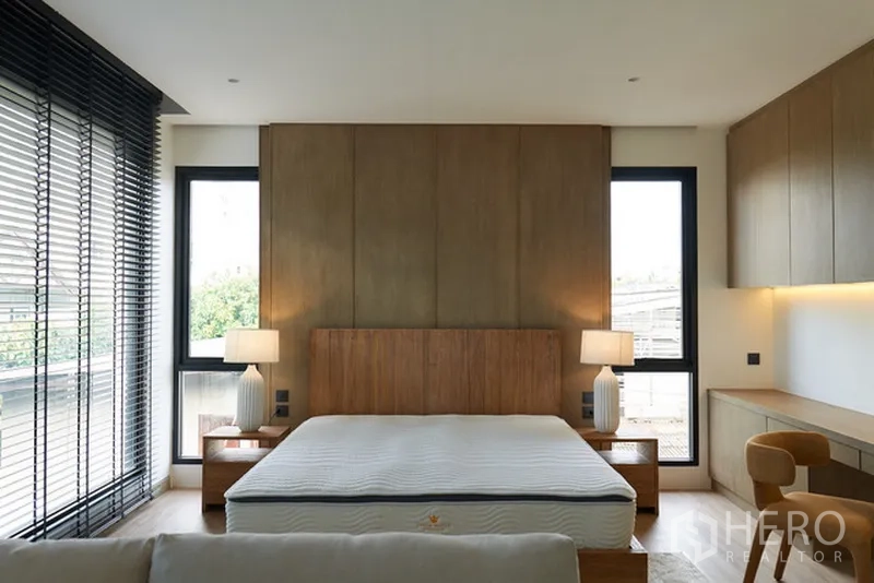 บ้าน ให้เช่าในWatthana, Bangkok - ห้องนอนใหญ่ หน้าต่างบานสูง ผนังไม้ และโต๊ะทำงานบิลท์อิน