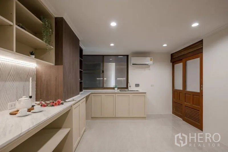Condominium for sale - Modern kitchen with light cabinetry and stone countertops.