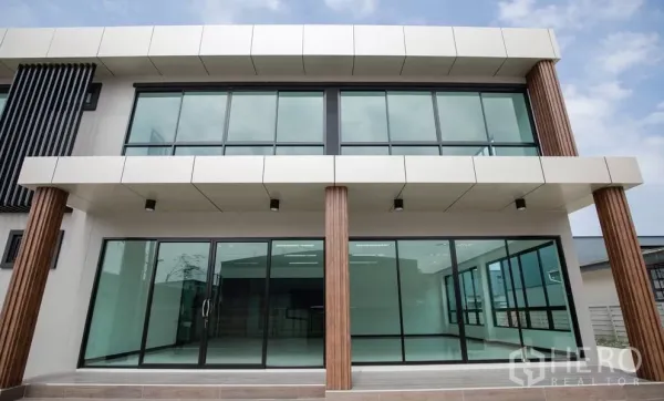 Factory for rent or sale in Bang Len, Nakhon Pathom - Front facade of the factory office with floor-to-ceiling glass doors and wood-accent columns.