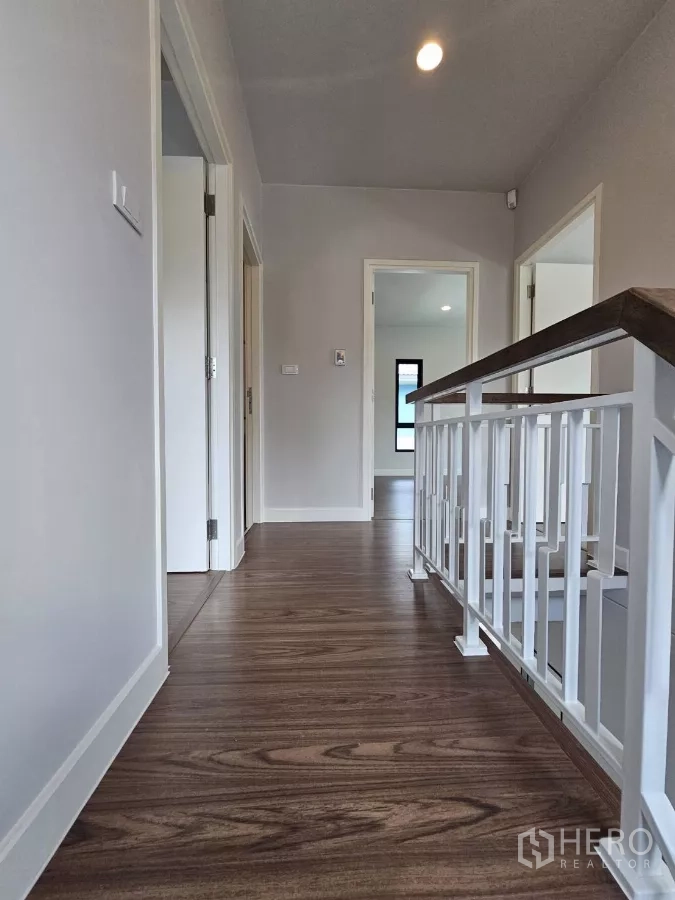 บ้าน ขายในLam Luk Ka, Pathum Thani - โถงชั้นบนพื้นไม้ลามิเนตและราวบันไดสีขาว