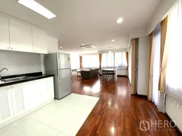 คอนโด ให้เช่าในWatthana, Bangkok - คอนโดสว่างโปร่งแบบโอเพ่นสเปซ ครัวตัว U สีขาว ตู้เย็นสแตนเลส พื้นไม้ และหน้าต่างบานใหญ่พร้อมผ้าม่าน