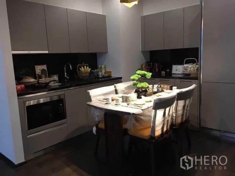 คอนโด ให้เช่าในWatthana, Bangkok - ครัวสไตล์โมเดิร์นตู้สีเทา เคาน์เตอร์หิน พร้อมโต๊ะทานข้าว 4 ที่และบอนไซ