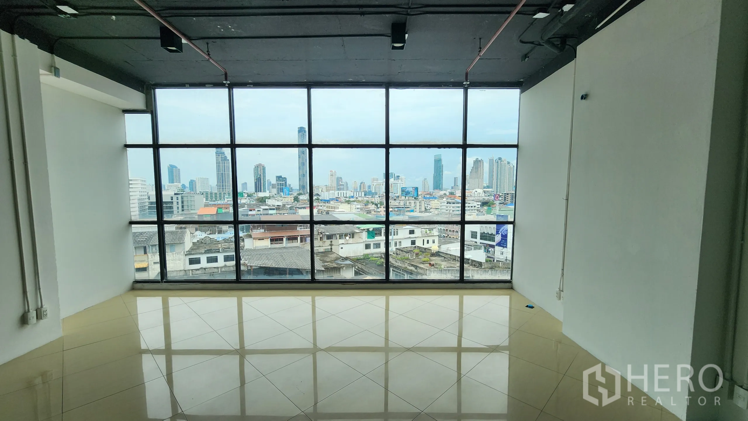 Office Space for rent in Yan Nawa, Bangkok - Corner room with black-framed windows and adjacent glass partitioned office.