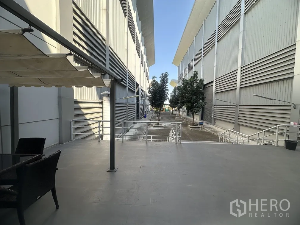 Factory for rent in Lam Luk Ka, Pathum Thani - Covered terrace and rest area overlooking the service lane between halls.
