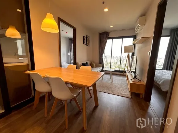 Condominium for rent in Chatuchak, Bangkok - Open-plan dining and living room with large windows and balcony rail.