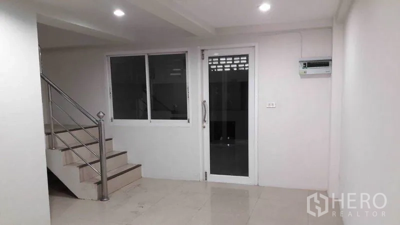 Office Space for rent in Bueng Kum, Bangkok - Stainless-steel staircase beside a glass door and window in a bright office area.