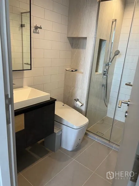 公寓 出租在Chatuchak, Bangkok - 现代卫浴，带台盆、瓷砖墙面与玻璃淋浴间。