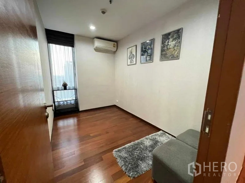 公寓 出租在Watthana, Bangkok - 第二卧室/书房，木地板、墙面装饰画与窗户。