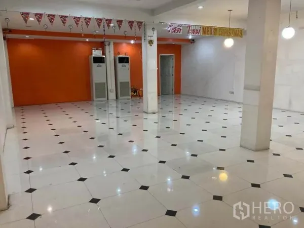 店屋 出租在Suan Luang, Bangkok - 大型零售大厅，橙色特色墙、立柱、天花灯和柜式空调。