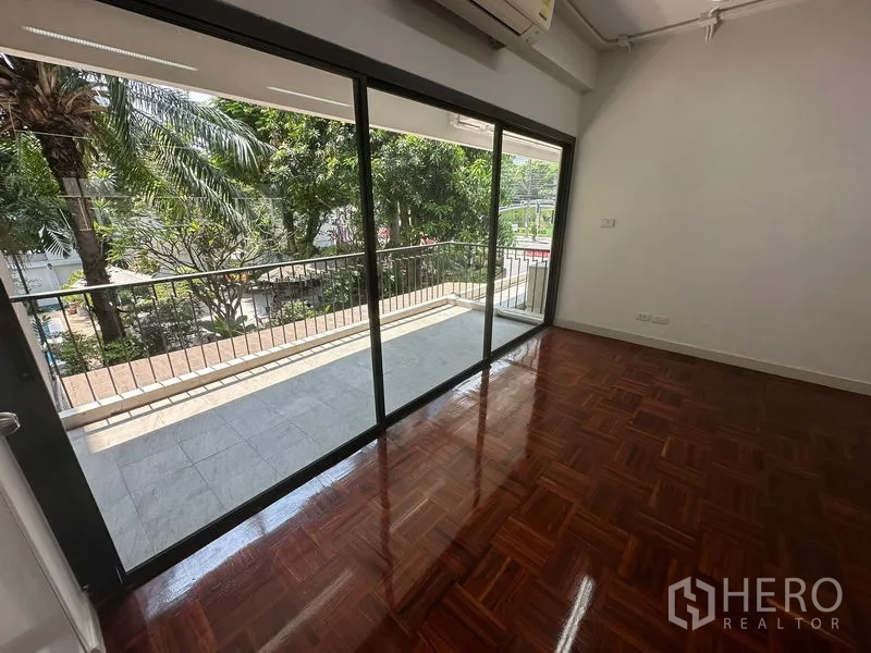 办公空间 出租 - 带大型玻璃门的独立办公室，连接阳台，可欣赏绿树景观。