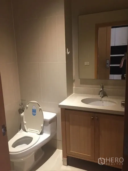 คอนโด ให้เช่า - ห้องน้ำแขกพร้อมอ่างล้างหน้า กระจก และโถสุขภัณฑ์ โทนสีอบอุ่น