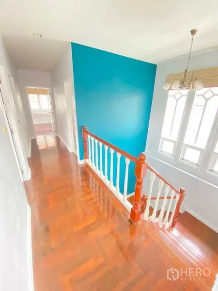 独立式住宅 出租 - 二层走廊，抛光木地板，青绿色强调墙与拱形窗。