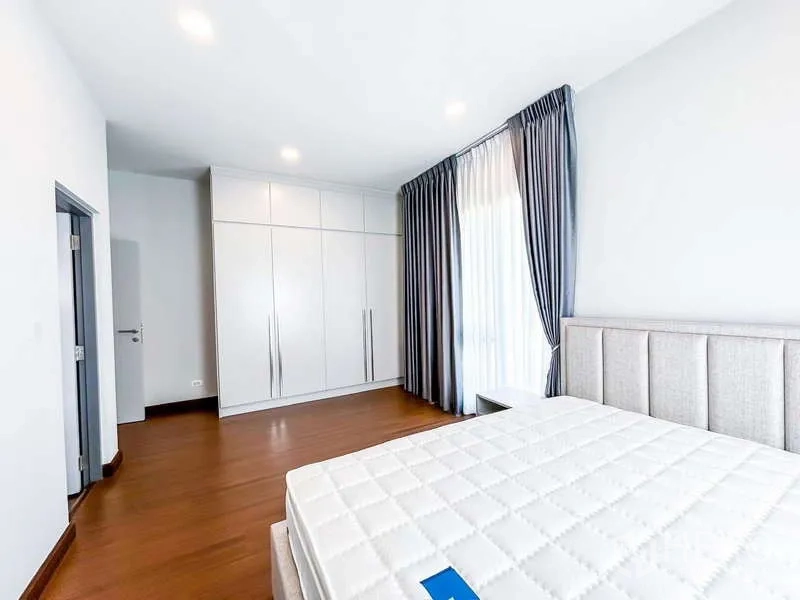 Detached House for rent in Bang Phli, Samut Prakan - Sunlit bedroom featuring a large built-in wardrobe, bed and tall grey curtains.